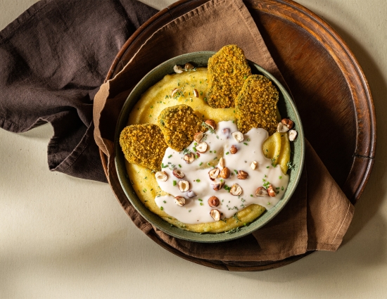 Mini cotolette con polenta morbida alle erbe, fonduta e nocciole tostate